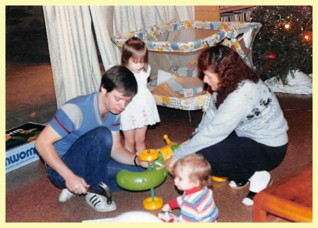 J and Yolanda assembling Christmas toys with Sam and Alex supervising