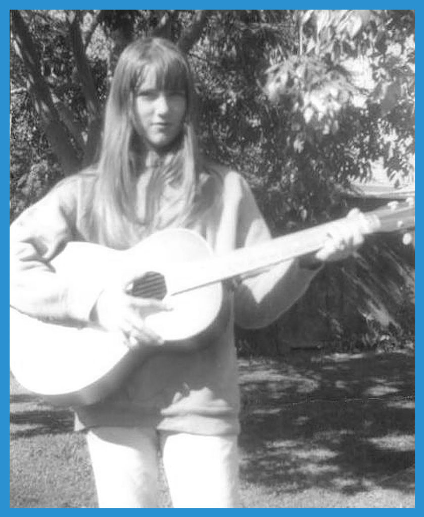 Monkees fan sister Janet with guitar in backyard.